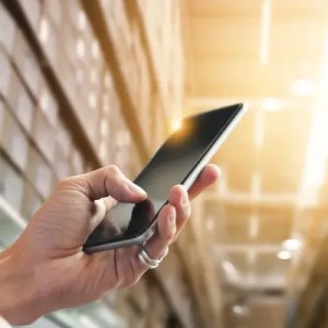 Warehouse worker using phone to check facility.